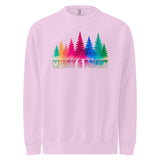 A pink sweatshirt with a graphic design featuring a line of colorful trees and the text "MERRY & BRIGHT" below them.